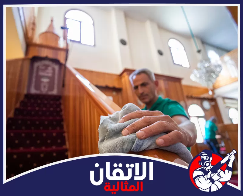 مسح وتعقيم درابزين المنبر والأسطح الخشبية داخل المصلى.
